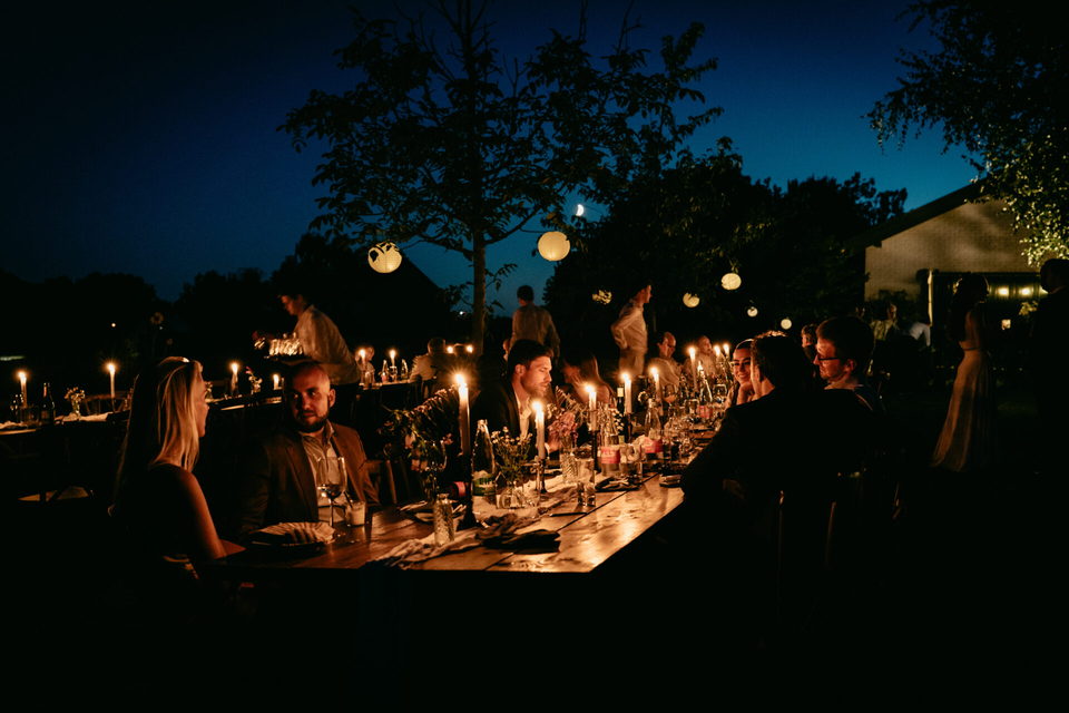 Lange Tafel im Freien in der blauen Stunde, Kerzen und Lichterketten