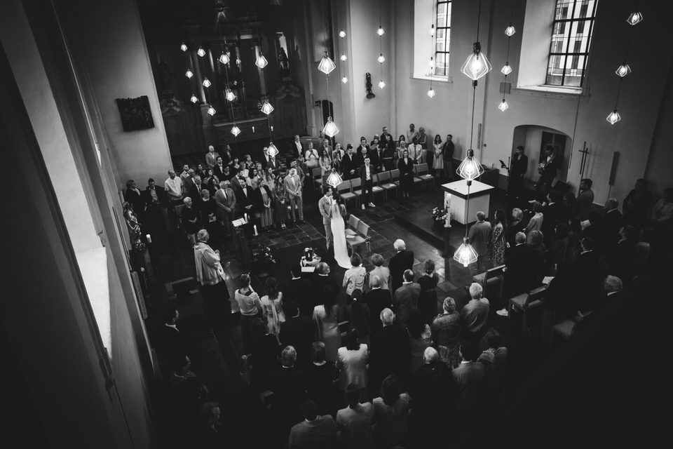 Blick von der Empore auf die Trauung in einer vollen Kirche